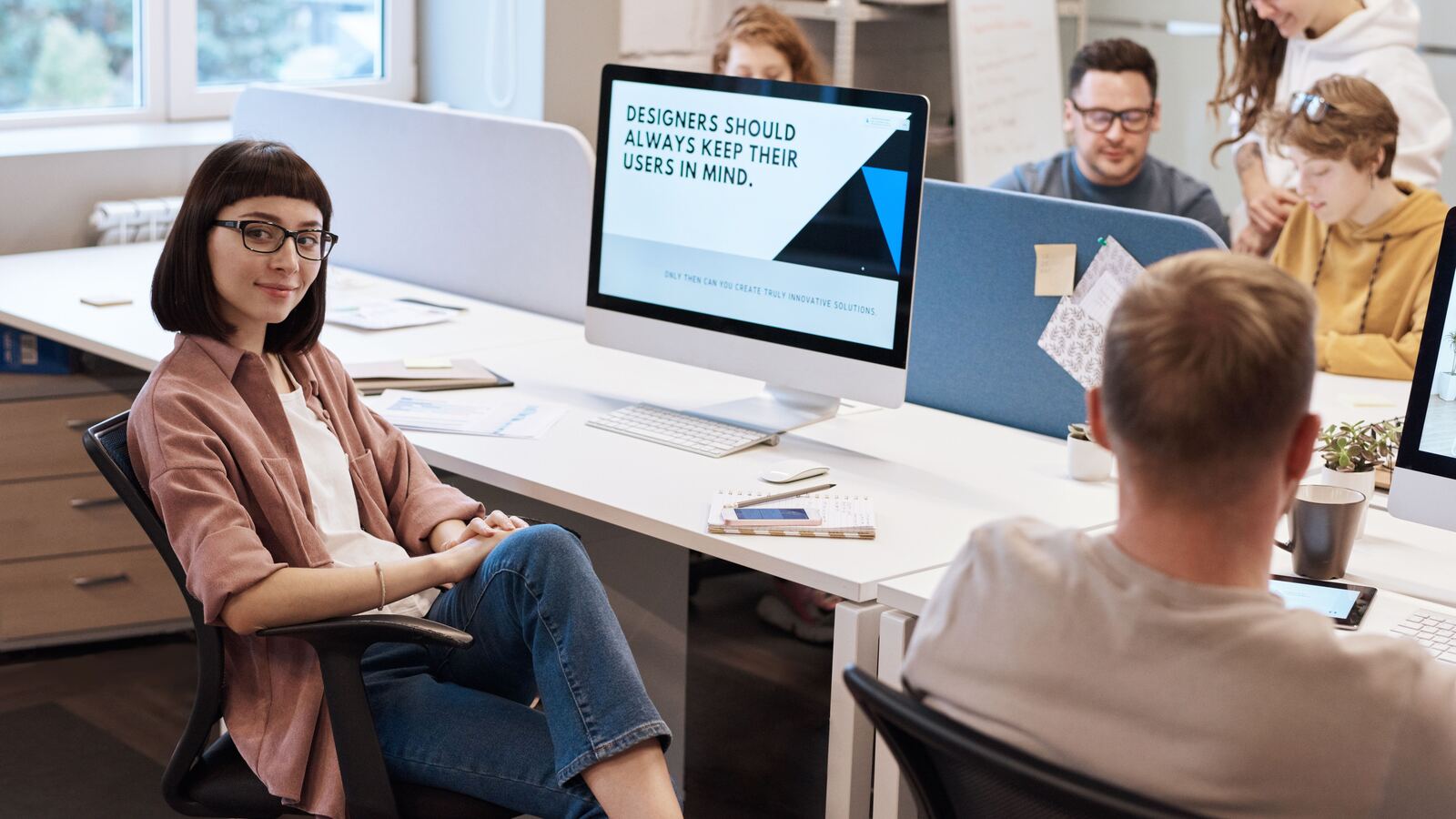 Professional confidently discussing her work with a colleague in a modern office